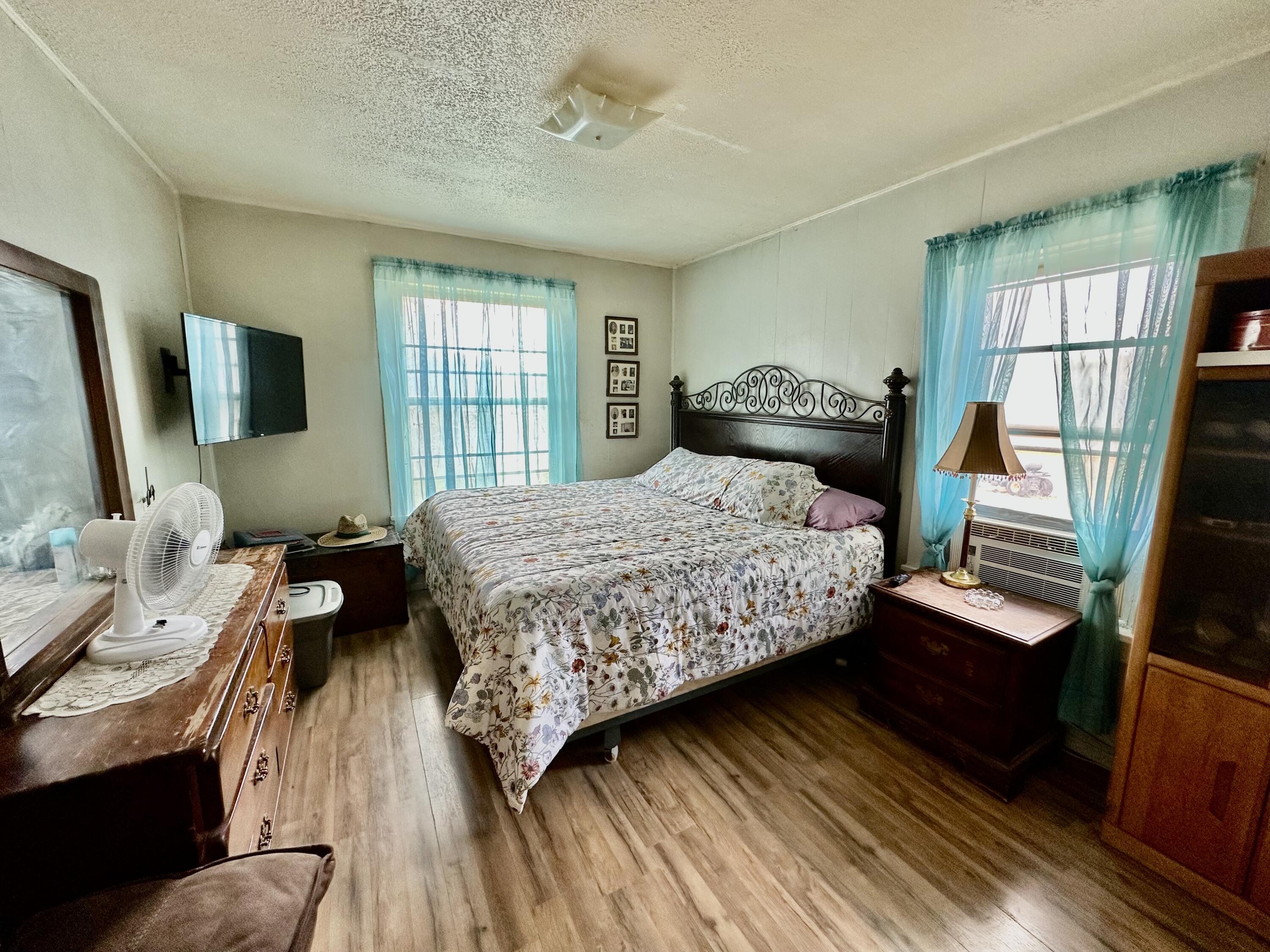 907 Co Road Turkey, TX 79261 - Photo 17 of 24 a bedroom with a bed wooden floor and window