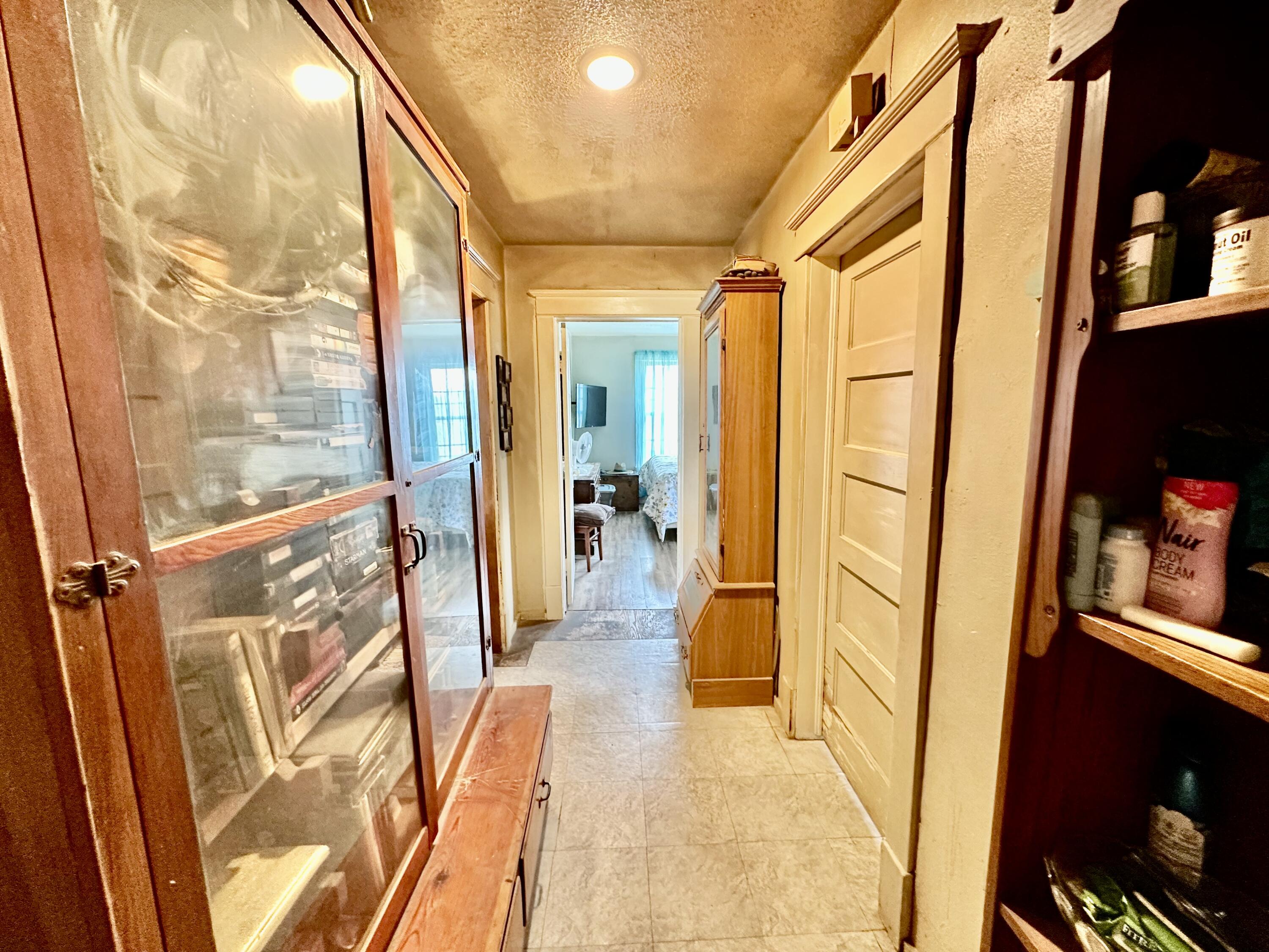 907 Co Road Turkey, TX 79261 - Photo 19 of 24 a view of hallway with wooden floor and a mirror