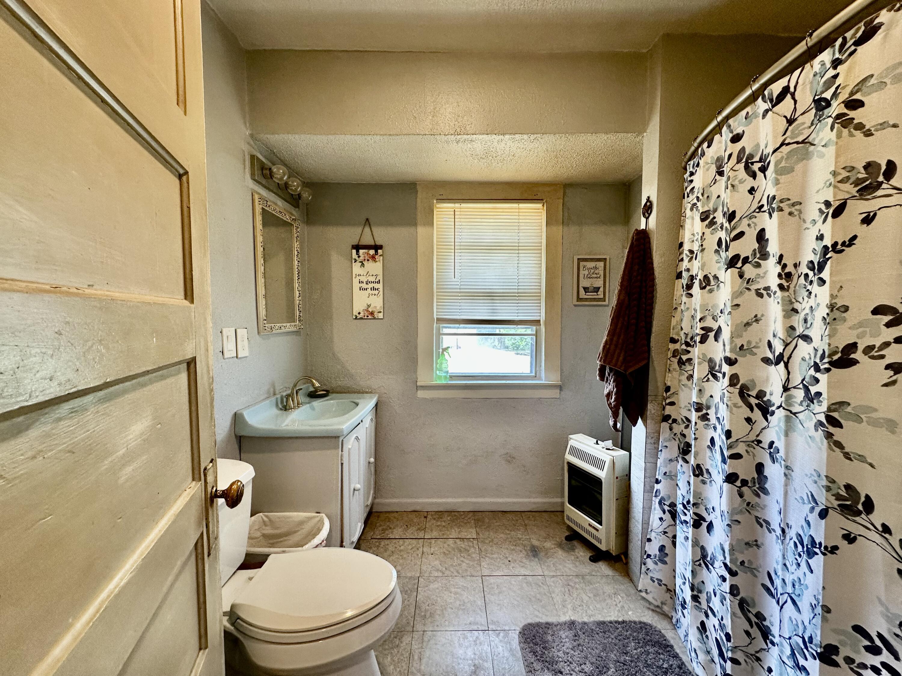 907 Co Road Turkey, TX 79261 - Photo 20 of 24 a bathroom with a toilet and a shower curtain