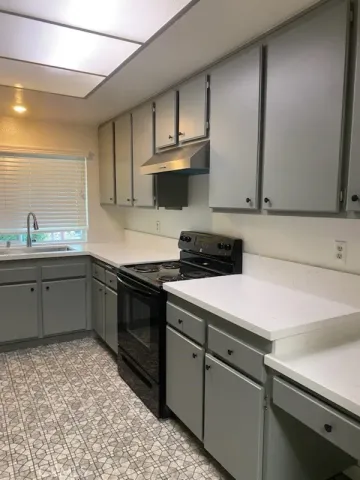 a kitchen with stainless steel appliances a sink dishwasher stove and cabinets