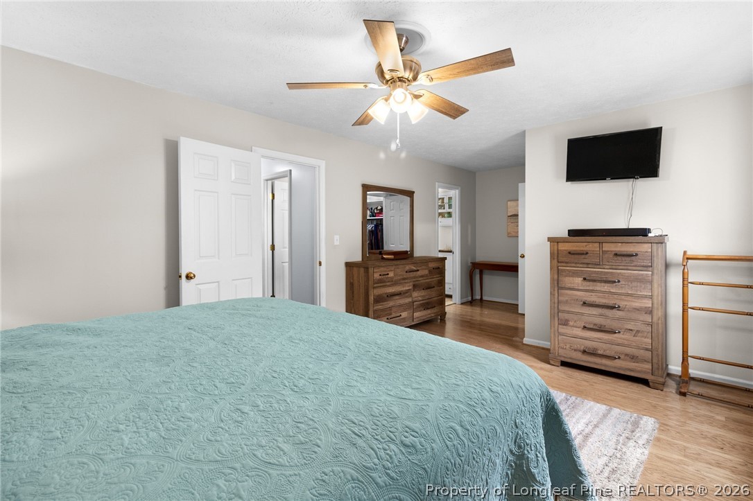 3488 School Road Fayetteville, NC 28306 - Photo 21 of 50 a spacious bedroom with a bed and a flat screen tv
