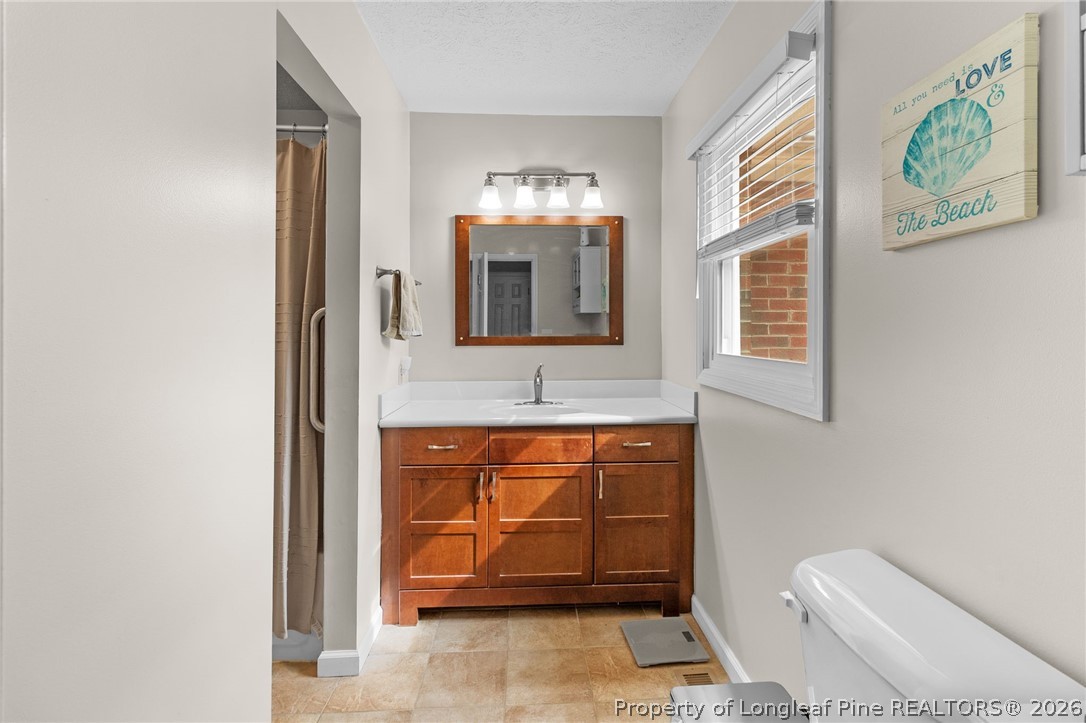 3488 School Road Fayetteville, NC 28306 - Photo 23 of 50 a bathroom with a toilet a sink and mirror