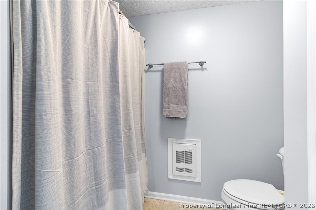 3488 School Road Fayetteville, NC 28306 - Photo 30 of 50 a white toilet sitting next to a shower curtain