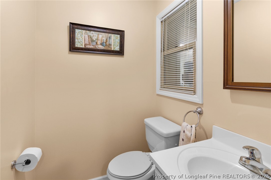 3488 School Road Fayetteville, NC 28306 - Photo 34 of 50 a white toilet sitting next to a bathroom sink