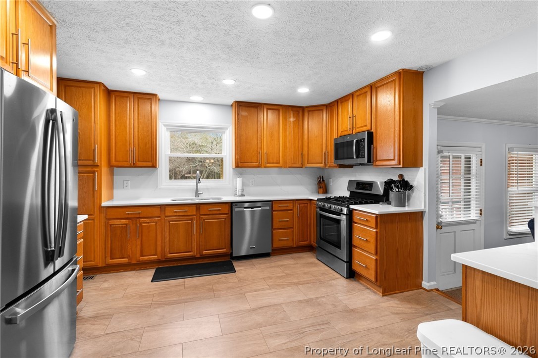 3488 School Road Fayetteville, NC 28306 - Photo 9 of 50 a kitchen with stainless steel appliances granite countertop wooden cabinets a stove a sink a refrigerator and a microwave