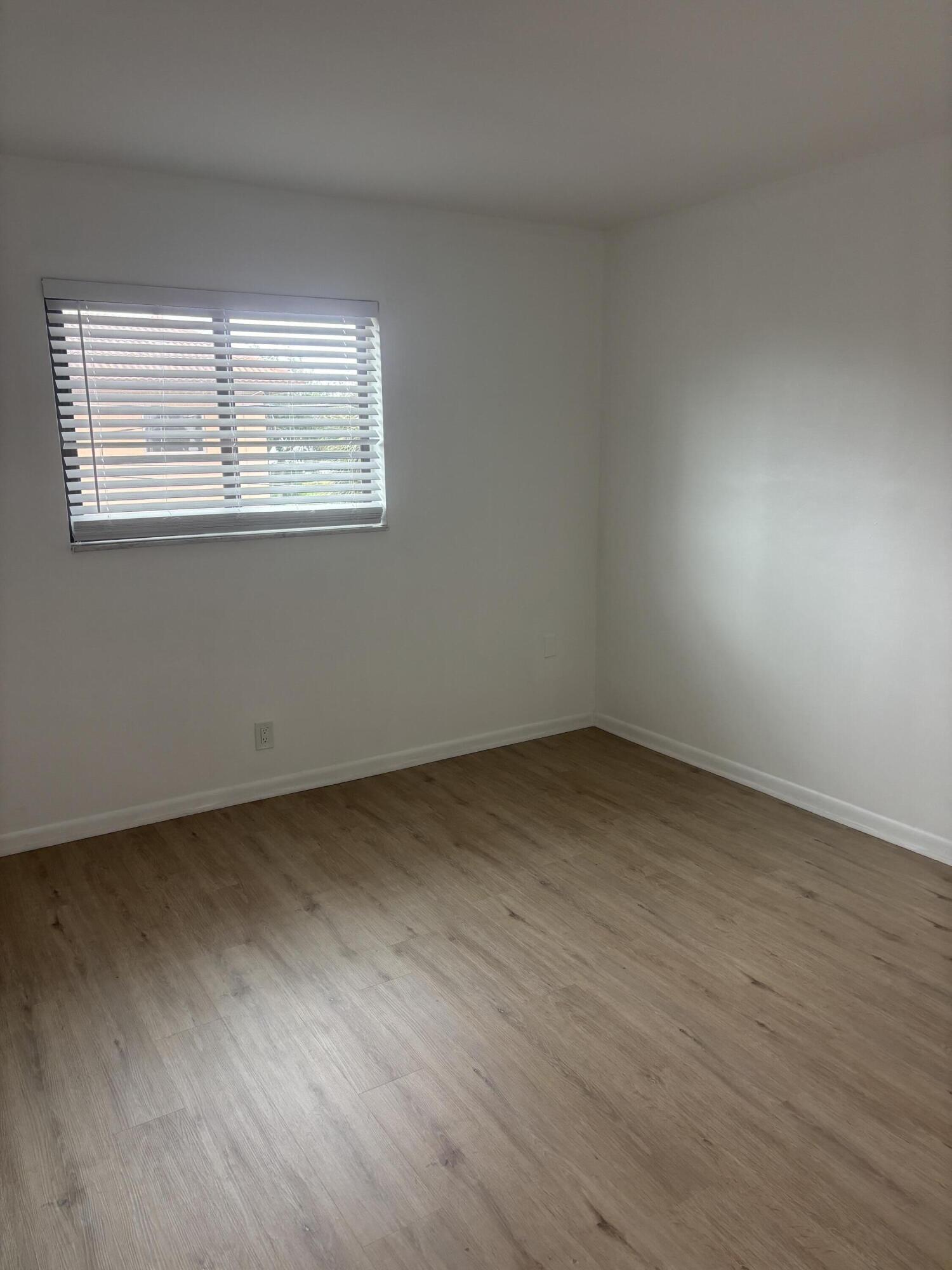 521 Northeast 45th Street Boca Raton, FL 33431 - Photo 16 of 17 a view of an empty room with wooden floor and a window