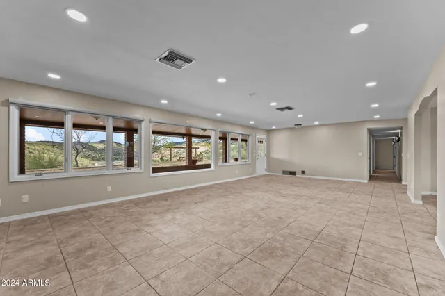 a view of an empty room with a fireplace and a window