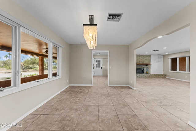 an empty room with windows and fireplace