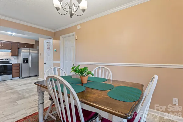 a view of a dining room with furniture and a chandelier