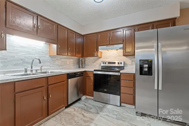 a kitchen with a sink refrigerator and cabinets