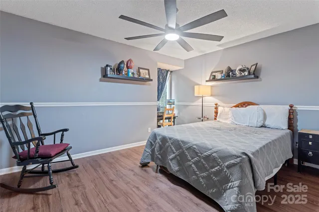 a bedroom with bed and wooden floor