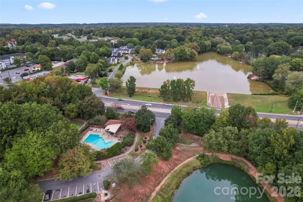 an aerial view of residential houses with outdoor space and lake view