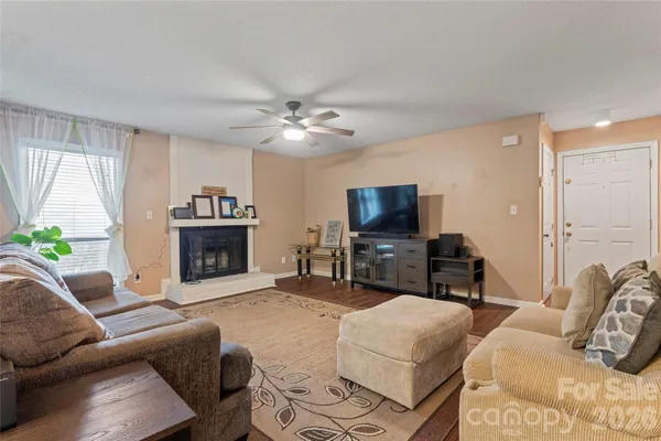a living room with furniture a fireplace and a flat screen tv