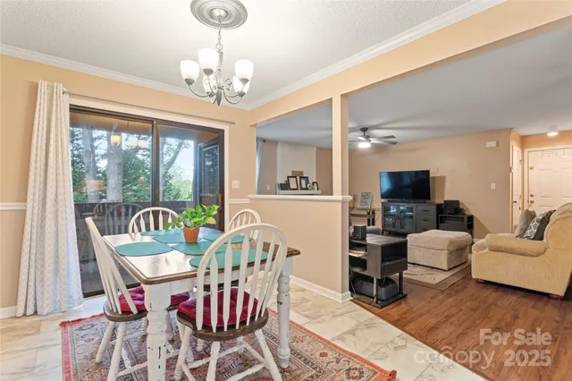 a view of a dining room with furniture a chandelier and wooden floor