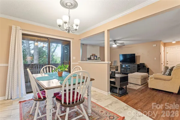 a view of a dining room with furniture a chandelier and wooden floor
