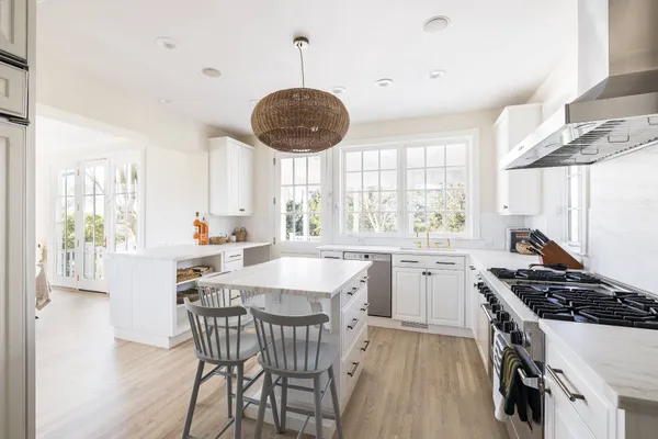a kitchen with stainless steel appliances a table chairs and a window