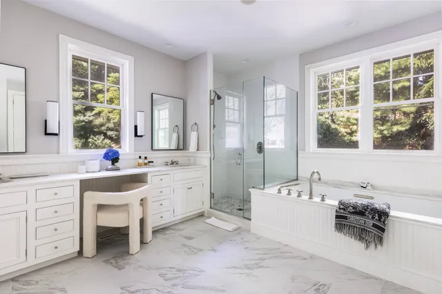 a spacious bathroom with a double vanity sink a tub and a window