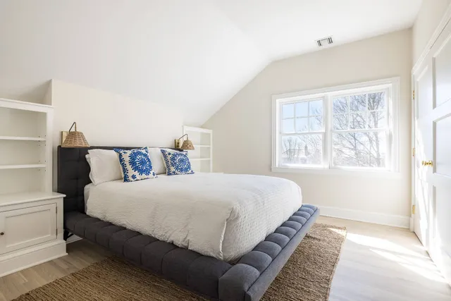 a bedroom with a large bed and a window