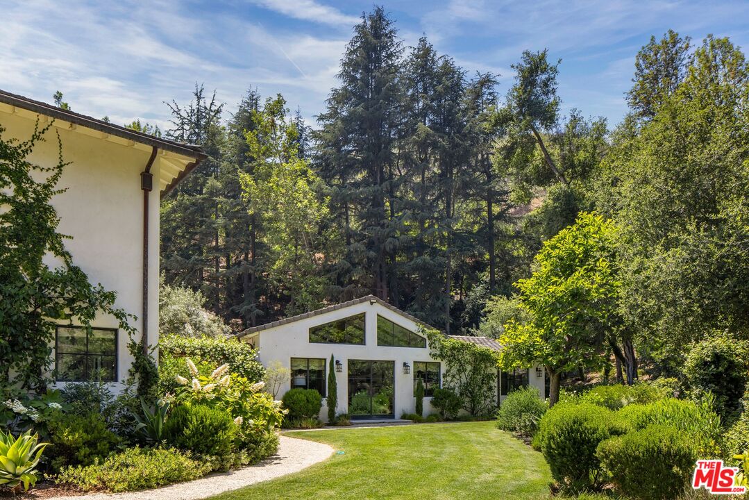 3099 Mandeville Canyon Road Los Angeles, CA 90049 - Photo 22 of 59 a front view of a house with garden