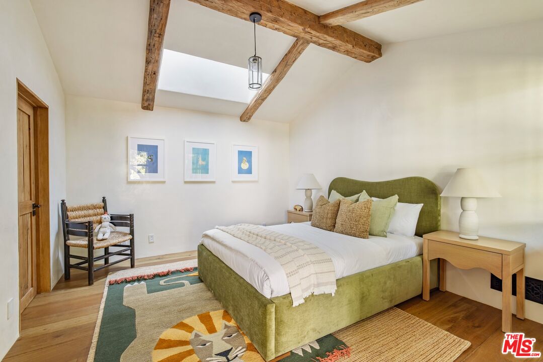 3099 Mandeville Canyon Road Los Angeles, CA 90049 - Photo 37 of 59 a bedroom with a bed and a table in it