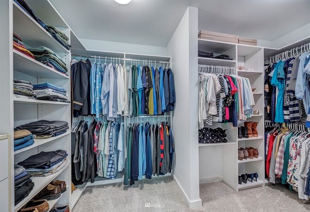 a view of walk in closet with clothes and shoes