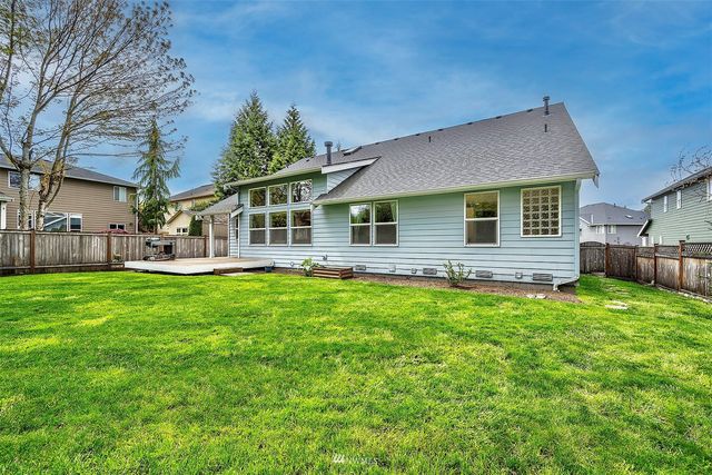 a view of a house with backyard and a tree