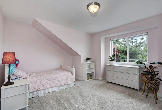 a bedroom with a bed and a table chair