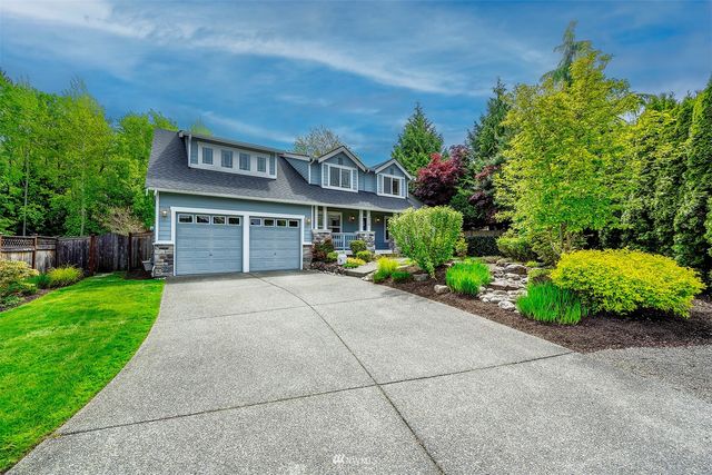 a front view of a house with a yard and potted plants