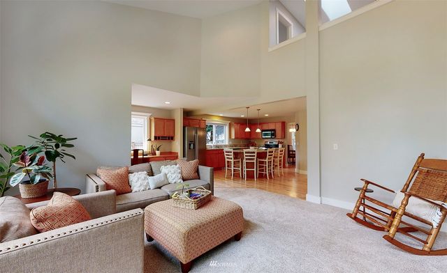 a living room with furniture and a dining table with wooden floor