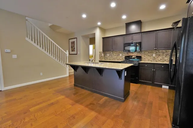 a view of kitchen island with granite countertop sink