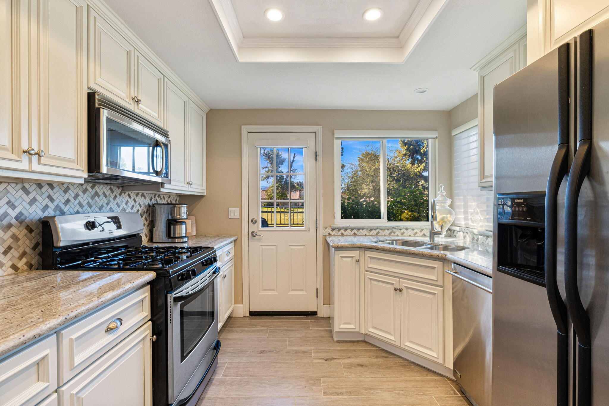 49091 Taylor Street Indio, CA 92201 - Photo 14 of 49 a kitchen with stainless steel appliances granite countertop a stove a sink and a refrigerator