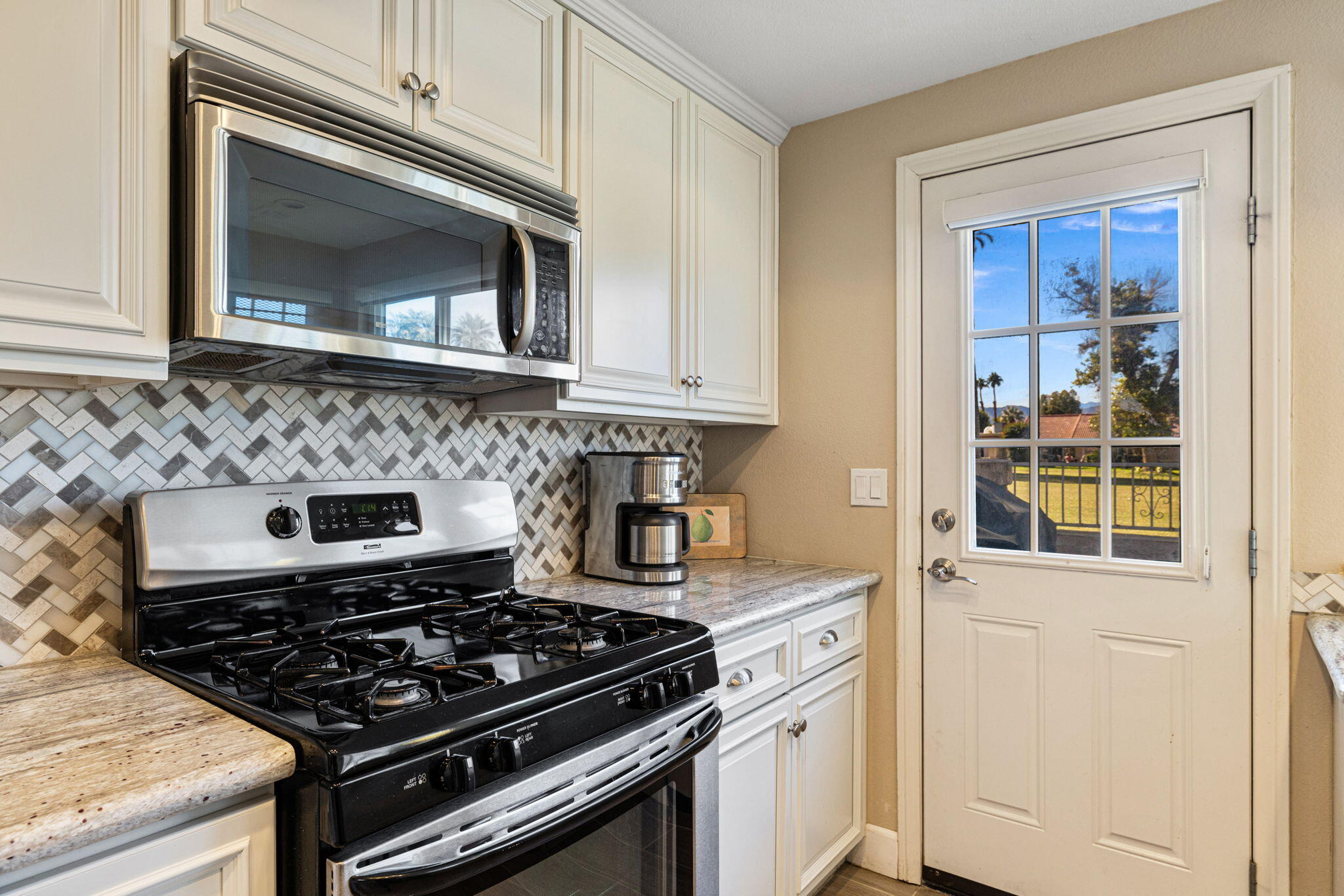 49091 Taylor Street Indio, CA 92201 - Photo 18 of 49 a kitchen with granite countertop a stove and a microwave