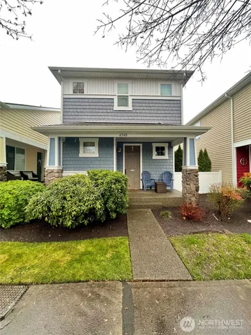 a front view of a house with a yard and potted plants