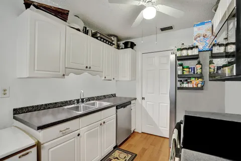 a kitchen with stainless steel appliances granite countertop a sink and a white cabinets