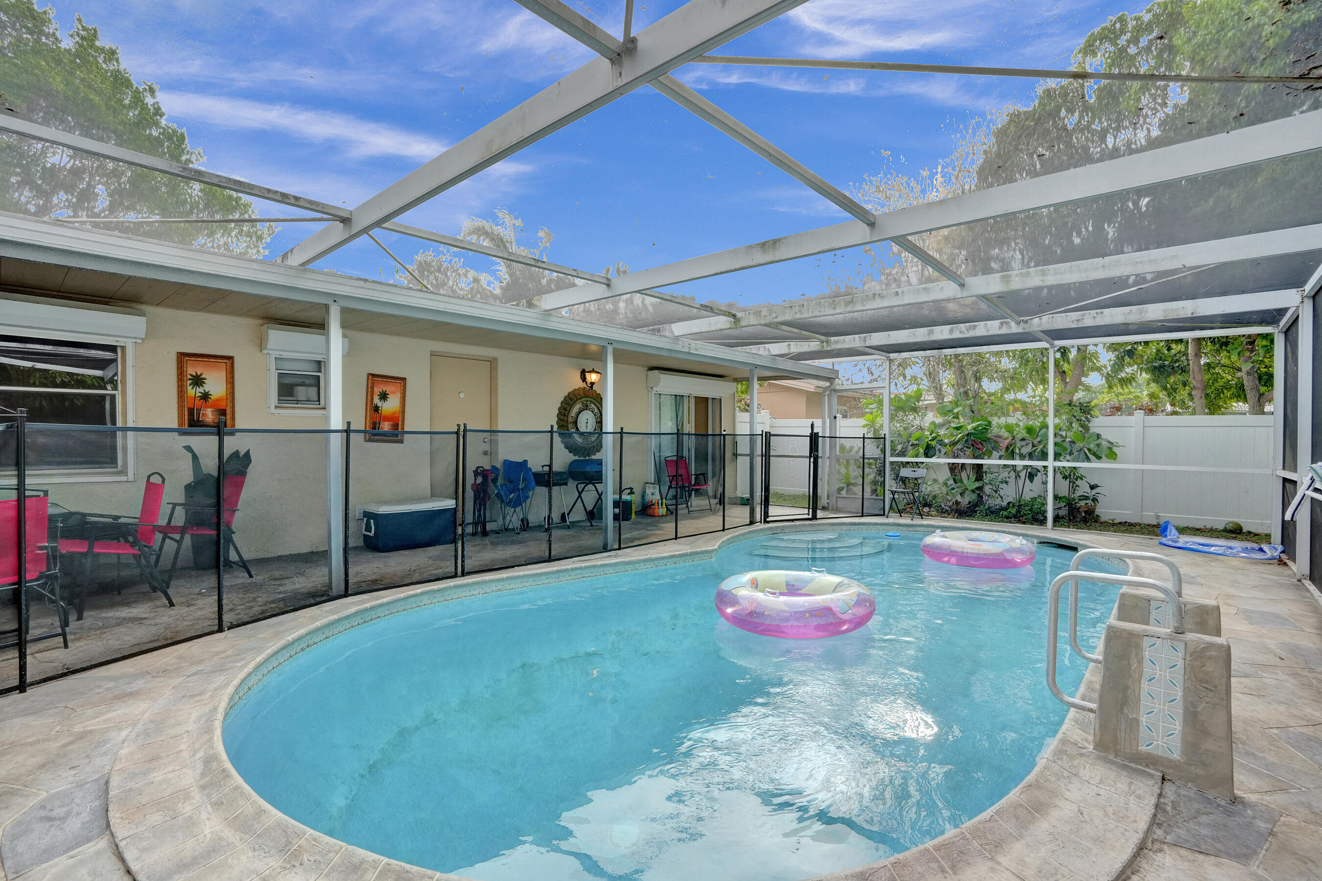 7697 Forest Boulevard North Lauderdale, FL 33068 - Photo 20 of 30 a view of a swimming pool with chairs and plants