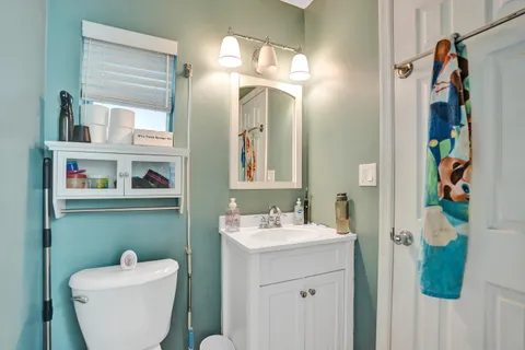 a bathroom with a toilet sink and mirror