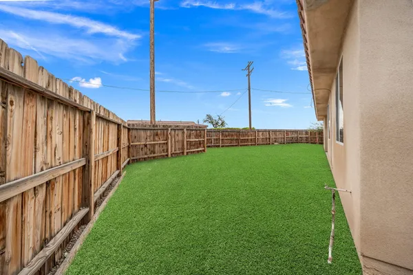 a view of a backyard with wooden fence
