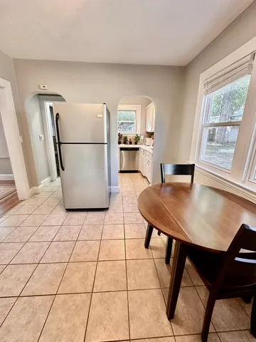 a kitchen with a refrigerator a stove a sink and a dining table