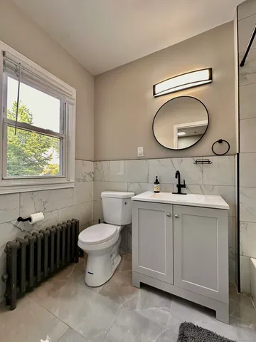 a bathroom with a toilet a sink and a mirror