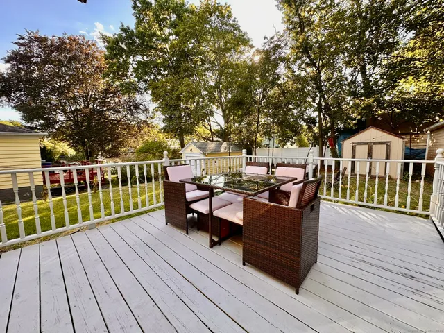a view of a house with wooden deck and furniture
