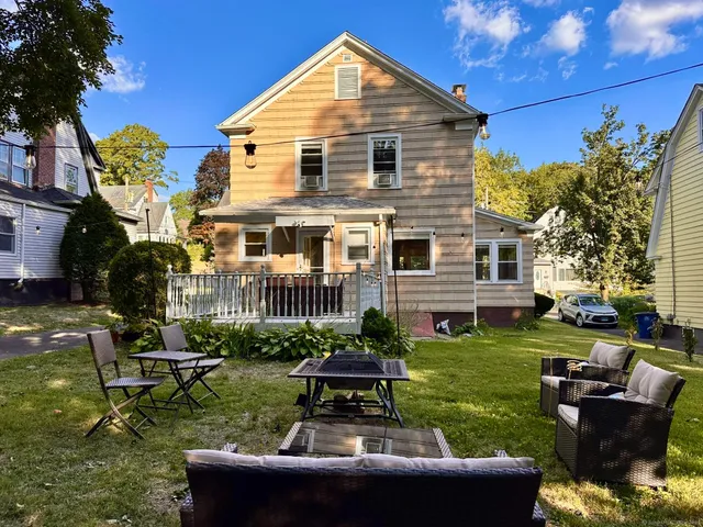 a view of a house with backyard sitting area and garden