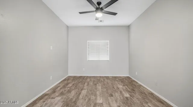 a view of a room with a ceiling fan and wooden floor