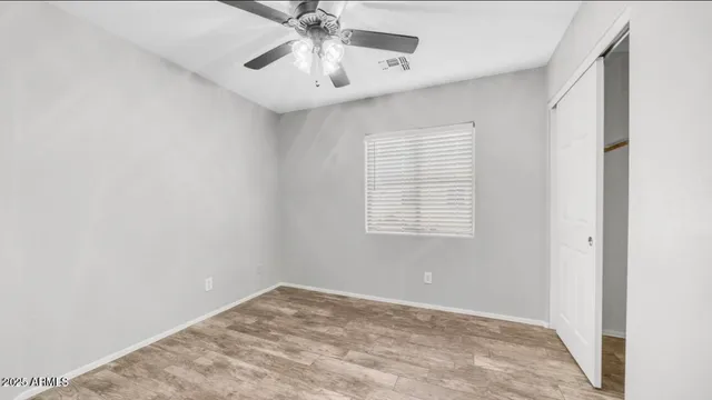 an empty room with a window and a fan
