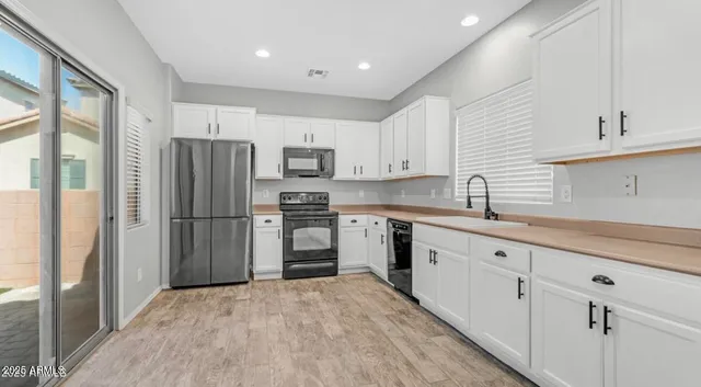 a kitchen with stainless steel appliances a refrigerator sink and cabinets