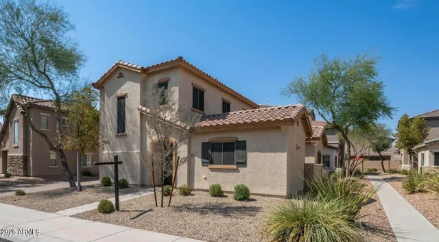 a view of a white house with large windows next to a road