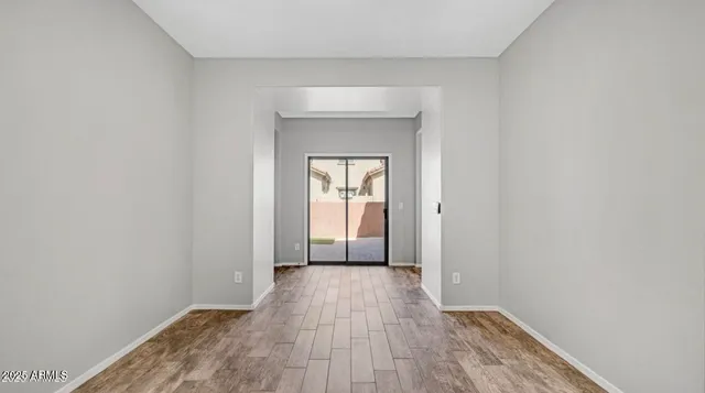 a view of a hallway with wooden floor and a window