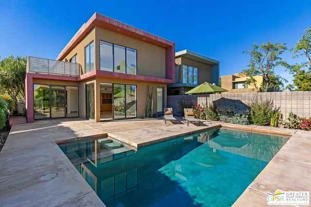 a front view of a house with swimming pool having outdoor seating