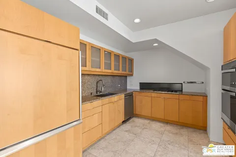 a kitchen with stainless steel appliances granite countertop a refrigerator and a stove top oven