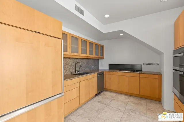 a kitchen with stainless steel appliances granite countertop a refrigerator and a stove top oven