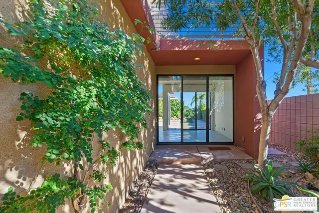 a front view of a house with a large tree